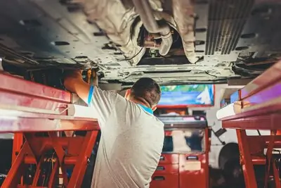 mechanic working underneath a car